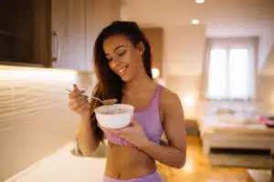 Beautiful fit woman eating healthy food after fitness workout